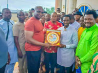 Chief Ogbuku receiving Badge of Honour presented by Comrade Johnny Jonathan