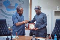 The Administrator of the Presidential Amnesty Programme, Chief (Dr) Dennis Brutu Otuaro presenting a plaque to Sir Jonathan Lokpobiri Snr, National President of Ijaw Youth Council during the visit