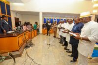 Governor Sim and the new chairmen as they take oath of office.