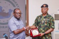 The Administrator of the Presidential Amnesty Programme Dr Dennis Otuaro (left) presenting a souvenir plaque to Maj Jamil during the latter's visit to the PAP office